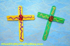 two wooden crosses decorated with beads on a blue tablecloth and white clouds in the background