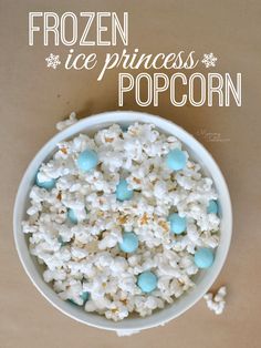 frozen ice princess popcorn in a bowl with blue and white candies on the side