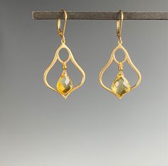 "Introducing our stunning Citrine earrings - the perfect accessory to add a touch of elegance to any outfit. Made with exquisite craftsmanship and attention to detail, these earrings showcase the beauty of the golden yellow Citrine stone. Crafted with high-quality materials, these earrings are designed to last, and their timeless style ensures they will never go out of fashion. The Citrine dangles within a Moroccan inspired shape of brushed Vermeil gold. The sparkling Citrine stone is set in a d Elegant Gold Faceted Crystal Earrings, Elegant Gemstone Teardrop Chandelier Earrings, Yellow Gemstone Earrings For Wedding, Elegant Citrine Jewelry With Gemstone Accents, Elegant Teardrop Crystal Gemstone Earrings, Elegant Faceted Chandelier Earrings, Elegant Yellow Crystal Dangle Earrings, Elegant Yellow Dangle Crystal Earrings, Elegant Formal Citrine Earrings