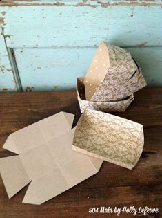 several pieces of paper sitting on top of a wooden table next to an open box