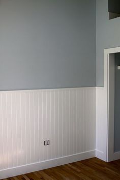 empty room with white paneling and wood floors