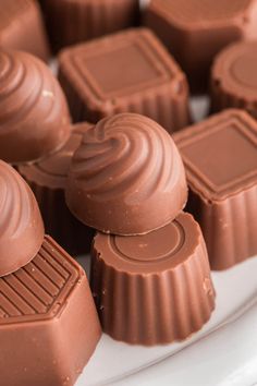 some chocolates are sitting on a white plate