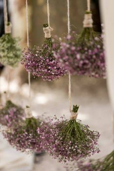 purple flowers are hanging from strings in the air