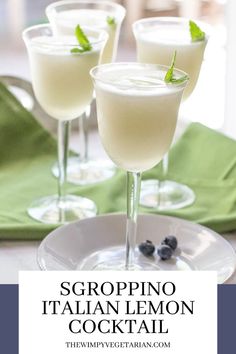 three glasses filled with italian lemon cocktail on top of a white plate and green napkin