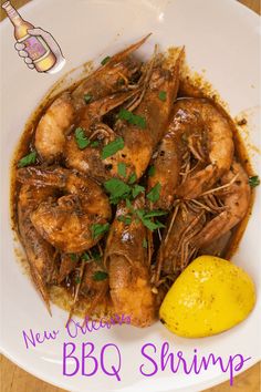 a white plate topped with shrimp next to a lemon wedge