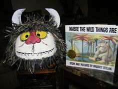 there is a stuffed animal that has been placed next to a sign with the words where the wild things are