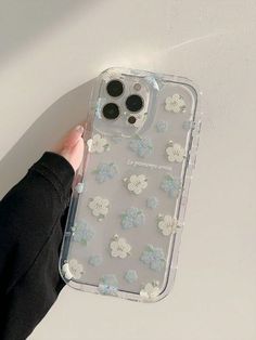 someone is holding up their phone case with flowers on the front and back cover in clear