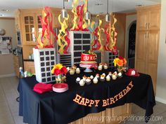 a birthday cake and cupcakes are on a table in the middle of a kitchen