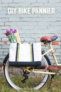 a bicycle with a bag on the back parked in front of a brick wall that says diy bike pannier