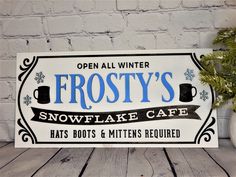 frosty's snowflake cafe sign sitting on top of a wooden table