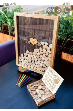 a wooden box filled with lots of wood chips next to a card board and markers