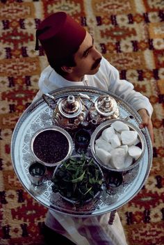 a man holding a platter with food on it