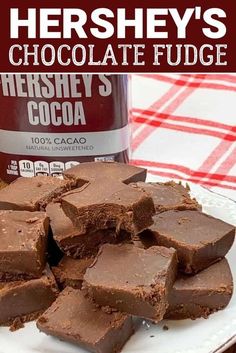 chocolate fudge on a plate next to a can of hershey's cocoa