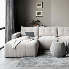 a living room with a white couch and two stools