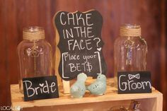 two birds are sitting in front of some glass jars with chalk writing on the sides