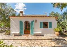 a small white house with blue shutters