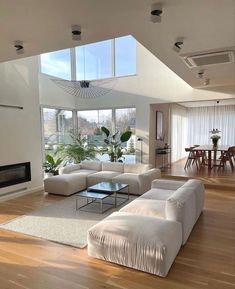 a living room with white furniture and large windows