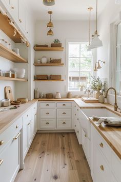 a kitchen with white cabinets and wooden counter tops, open shelving above the sink