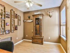 a living room with a grandfather clock on the wall and deer heads mounted to the wall