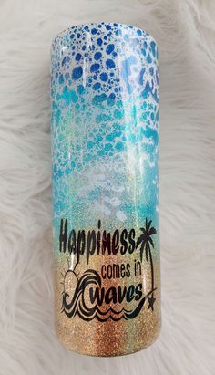 a blue and gold coffee mug with the words happiness comes in waves on it