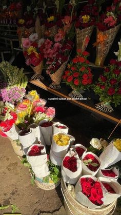 several buckets filled with flowers sitting next to each other