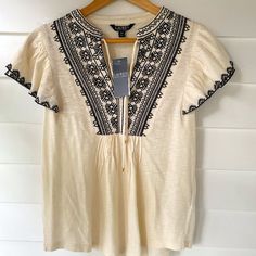 New With Tags! Lauren Ralph Lauren Women's Ivory Short-Sleeve Top With Black Embroidered Design At Chest. Flutter Sleeves. 100% Cotton. Machine Washable. Purchased New For $99.50. Excellent Condition! No Damage Or Markings. Casual Beige Embroidered Short Sleeve Top, Casual Beige Embroidered Summer Top, Spring Beige Short Sleeve Embroidered Top, Beige Short Sleeve Embroidered Top For Spring, Beige Short Sleeve Tops With Floral Embroidery, Casual Beige Embroidered Top, Cream Tops With Floral Embroidery, Cream Short Sleeve Tops With Floral Embroidery, Casual Embroidered Off White Tops