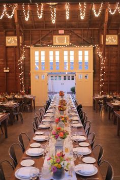 a long table is set up with plates and place settings for an event or gathering