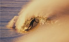 a man riding a wave on top of a surfboard