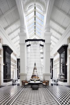 a large room with black and white checkered flooring, high ceilings and windows