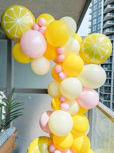 a bunch of balloons that are hanging from the side of a building with lemons on them