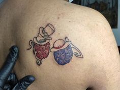 a tattoo on the back of a man's shoulder with an image of two teapots