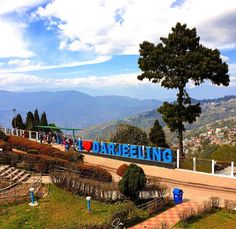 a sign that says darlieng on the side of a hill with mountains in the background