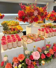 a table topped with lots of different types of flowers next to cakes and cupcakes