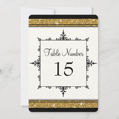 a table number card with gold glitter on the edges and a black border around it