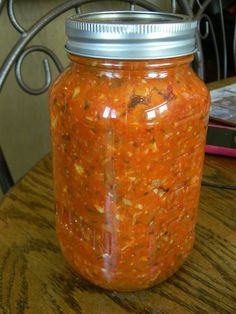 a jar filled with food sitting on top of a wooden table