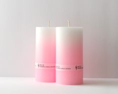 two pink candles sitting next to each other