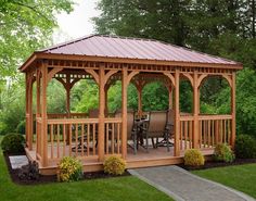 a wooden gazebo sitting on top of a lush green field