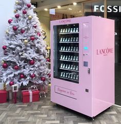 a pink vending machine next to a christmas tree