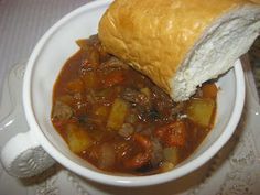 a white bowl filled with stew and a roll