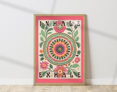 an art print with the words inhale and flowers on it, against a white wall