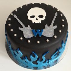 a black and blue cake decorated with skulls and guitars