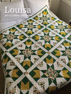 a bed with a green and yellow quilt on it