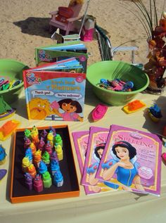 there are many books and toys on the table at this birthday party, including crayons