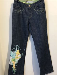 Disney Store Painted Tinkerbell Denim Jeans Size 2 Measures (while lying flat) Waist: 14"  Inseam: 30 Excellent Condition Ships from a smoke free, pet free home. Painted Jeans Disney, Y2k Butterfly Jeans, Disney Pants Jeans, 2000s Embroidered Jeans, Disney Patch Jeans, Disney Jeans, Tinkerbell Clothes, Tinkerbell Outfit, Painting Jeans