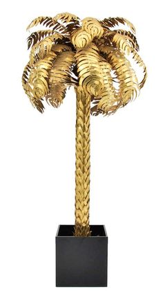 a gold palm tree sculpture in a black box on a white background with clipping for text