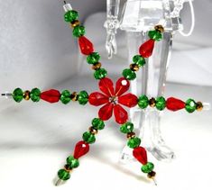 a red and green beaded christmas star ornament on a white table top