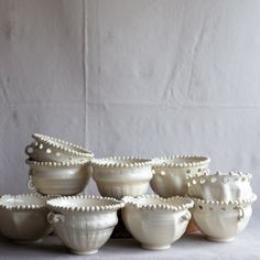 a group of white bowls sitting next to each other on top of a gray table