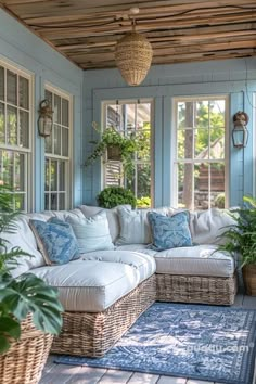 a living room filled with lots of furniture and plants on top of a wooden floor