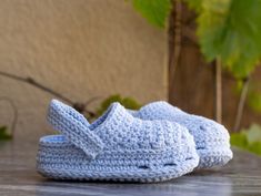 blue crocheted slippers sitting on top of a wooden table