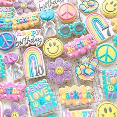 decorated cookies with happy birthday messages and smiley faces are displayed on cooling racks in front of a white background